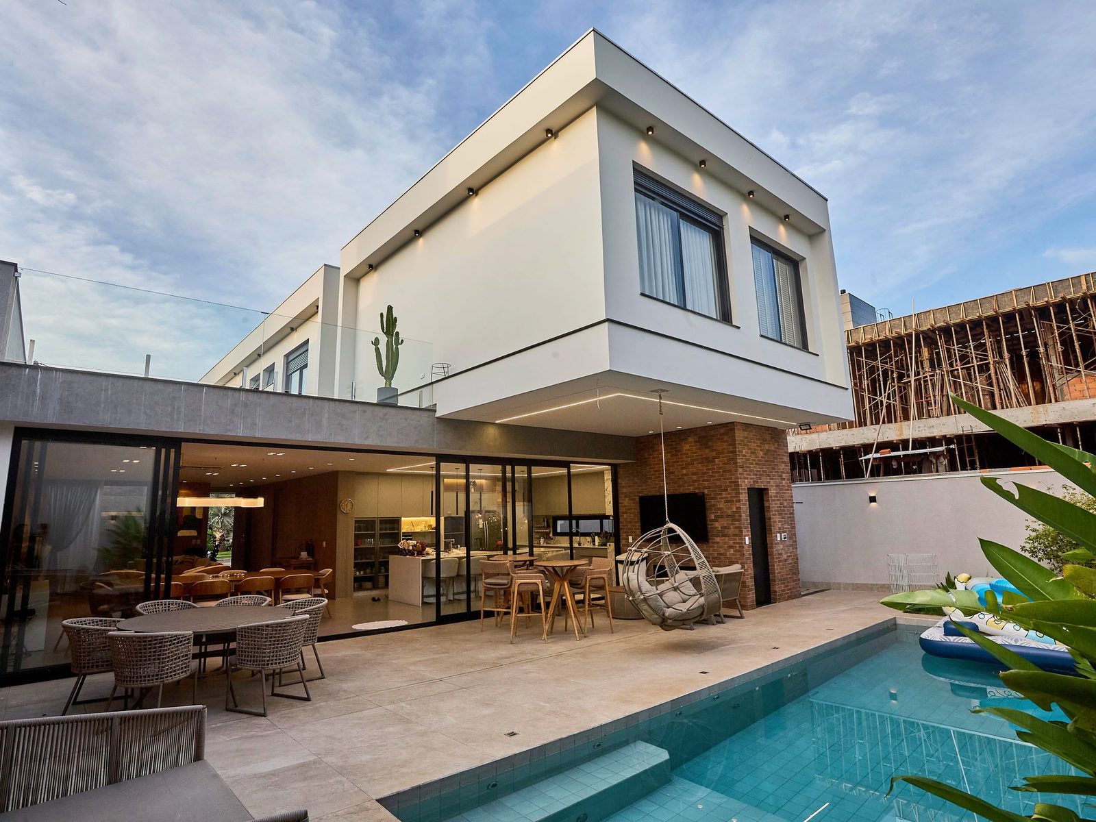 Modern house with a swimming pool and a building under construction next door